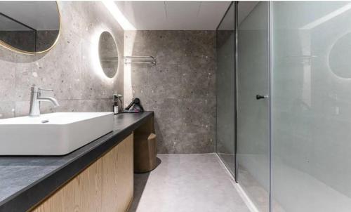 W łazience znajduje się umywalka i przeszklony prysznic. w obiekcie Hotel Lounge 7 w mieście Inczon