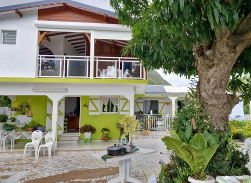 a house with a tree in front of it at Villa des fleurs in Pointe-Noire