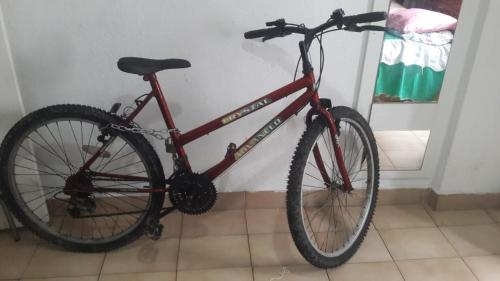 a red bike is leaning against a wall at frente ao mar in São Vicente