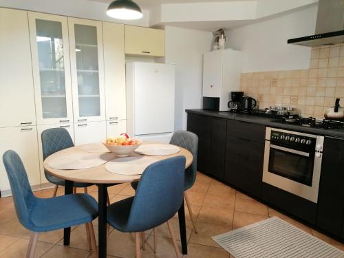 eine Küche mit einem Tisch mit Stühlen und einer Obstschale darauf in der Unterkunft Apartament u Przewodnika Sudeckiego in Duszniki-Zdrój