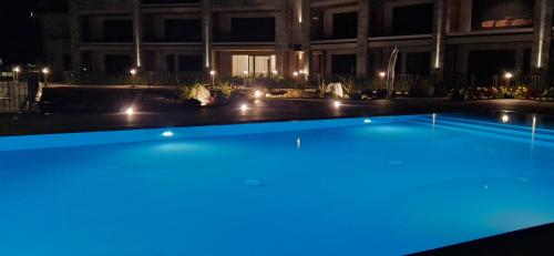 a large swimming pool in front of a building at night at Dany Lodge Lago di Como in Colico