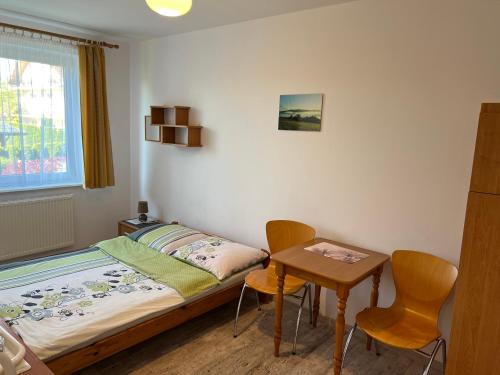 a bedroom with a bed and a table and chairs at Nad Bieszczadzkim Morzem in Polańczyk