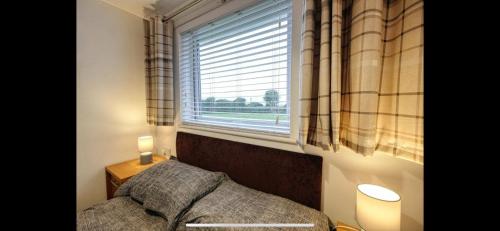 a bedroom with a bed and a large window at Kingfisher Holiday Park 1 Waveney Valley Great Yarmouth in Gorleston-on-Sea