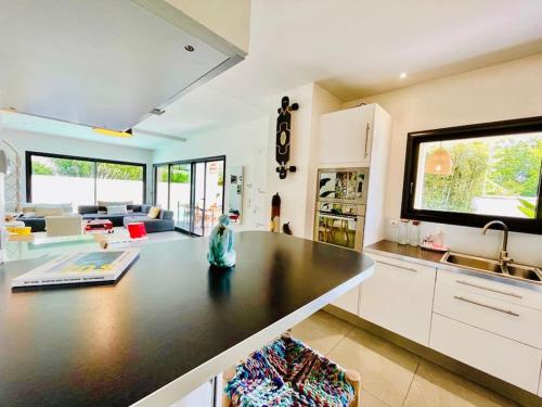 eine Küche und ein Wohnzimmer mit einer großen Arbeitsplatte in der Unterkunft Villa californienne 160m2 Piscine Parking in Bruges