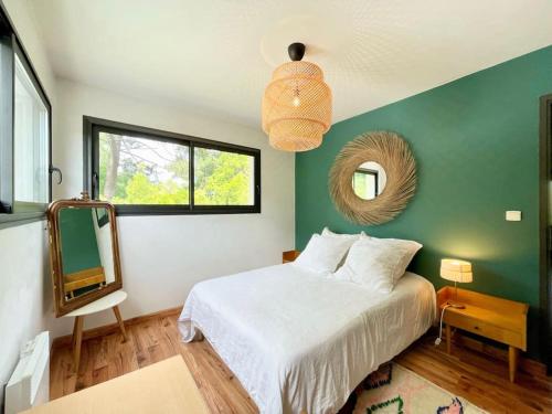 ein Schlafzimmer mit einem weißen Bett und einem Spiegel in der Unterkunft Villa californienne 160m2 Piscine Parking in Bruges