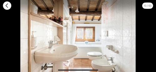 uma casa de banho branca com um lavatório e um WC em B&B Colle Paradiso 