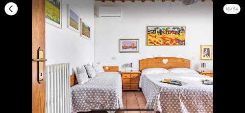 Duas camas num pequeno quarto com paredes brancas em B&B Colle Paradiso 
