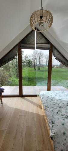 a bedroom with a bed and a large window at Agro domki u Kasi in Kazimierz