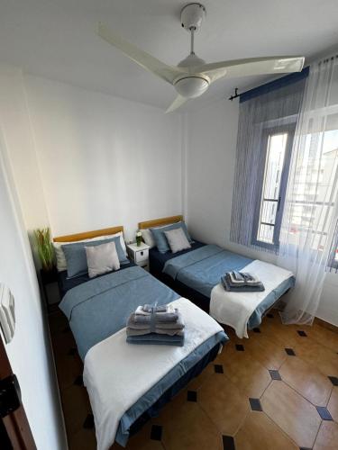 - une chambre avec 2 lits et un ventilateur de plafond dans l'établissement Apartamento Veracruz 200 m de la Playa, à Gandía