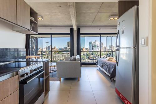une cuisine avec un réfrigérateur et un salon dans l'établissement Loft Elegante a 5 Minutos de Puerto Madero 6B, à Buenos Aires