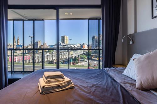 a bed with towels on it in a room with a window at Loft Elegante a 5 Minutos de Puerto Madero 6B in Buenos Aires