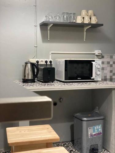 a kitchen with a counter top with a microwave at SRIINDO ARROiOS in Lisbon