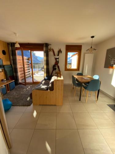 un salon avec une table et une salle à manger dans l'établissement La joue du loup, à Saint-Étienne-en-Dévoluy