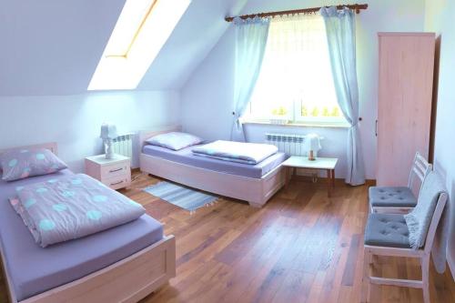 sypialnia z 2 łóżkami i oknem w obiekcie Polna Zagroda - domek do wynajęcia w Kielcach