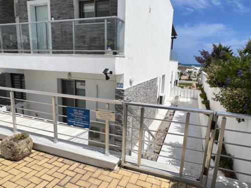 a white building with a gate and a balcony at The Best Apartment on the beach 'Caesar Beach' Bogaz, North Cyprus in Boğaz