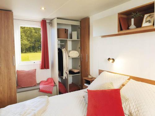 une chambre avec un lit avec des oreillers rouges et une fenêtre dans l'établissement Entre Mer et Etang !, à Canet