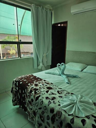 1 dormitorio con 1 cama con manta de estampado animal en Pousada Gale Orla, en Maragogi