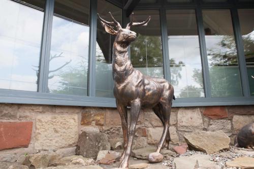 a statue of a deer standing in front of a building at Best Western Edinburgh South Braid Hills Hotel in Edinburgh