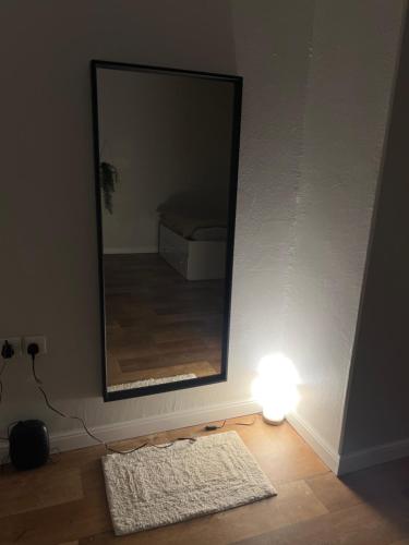 a mirror and a light in a room with a bed at غرفة بحي القدس بحمام مشترك in Riyadh