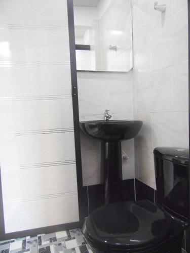 La salle de bains est pourvue d'un lavabo noir et de toilettes. dans l'établissement #2 Suit familiar a solo 1km de la hacienda Nápoles, à Doradal