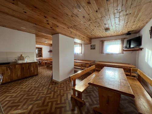 a large room with wooden tables and benches at Cicha Dolina in Cisna