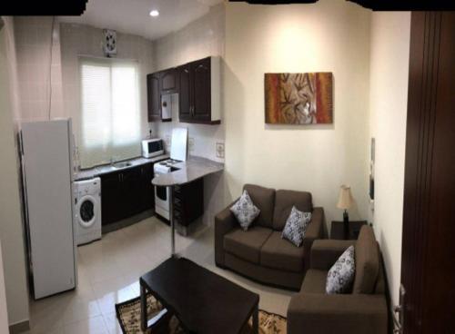 uma sala de estar com um sofá e uma cozinha em Samira House em Amã