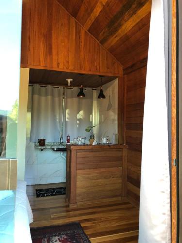 a room with a kitchen with wooden walls and ceilings at Chalé Sonho Diniz 2 in Monte Verde