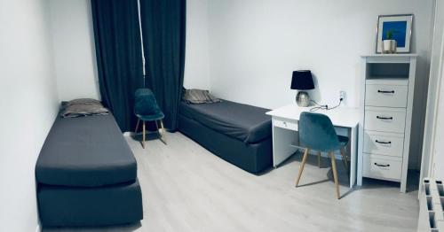 - une chambre avec un lit, un bureau, un lit et une chaise dans l'établissement Appartement Montpellier Sud 3 pièces, à Montpellier