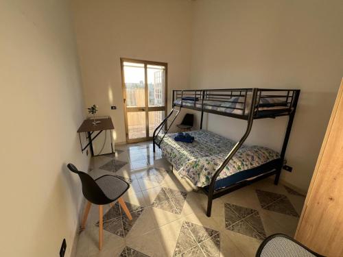 a bedroom with a bunk bed and a table and a chair at Villa Maria in Campobello di Mazara