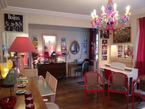 une salle à manger avec une table, des chaises et un lustre dans l'établissement Le Jardin de la Faisanderie, à Paris