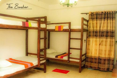 a room with three bunk beds in a room at The Bunker in Badulla
