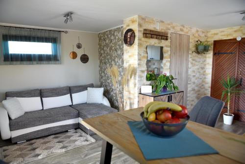 a living room with a bowl of fruit on a table at Jódi-Hegy Resort Siófok in Siófok
