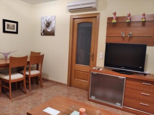 a living room with a television and a dining room table at Marvel apartamento Vinaros in Vinaròs
