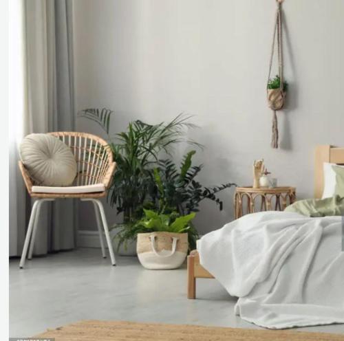 een slaapkamer met een bed en een stoel en planten bij Södertälje Karlhov Stay Inn in Södertälje