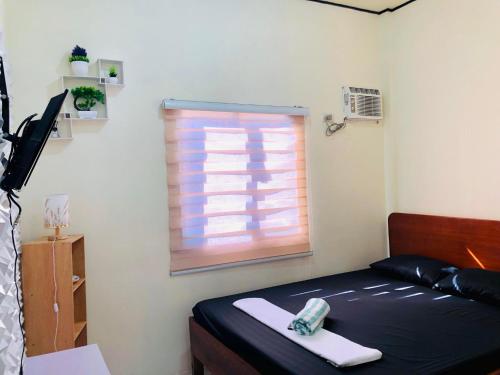 Kleines Zimmer mit einem Bett und einem Fenster in der Unterkunft Wakim’s INN in Coron