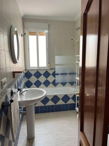 a bathroom with a sink and a tub at CH Apartamentos Luque in Luque