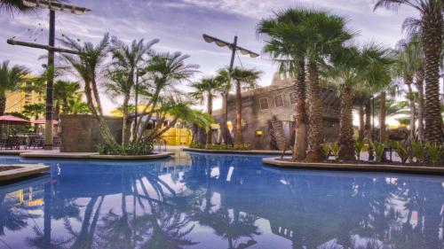 una piscina con palmeras frente a un edificio en 3 Minutes to Disney World - Bonnet Creek Resort 1 BD condo en Orlando