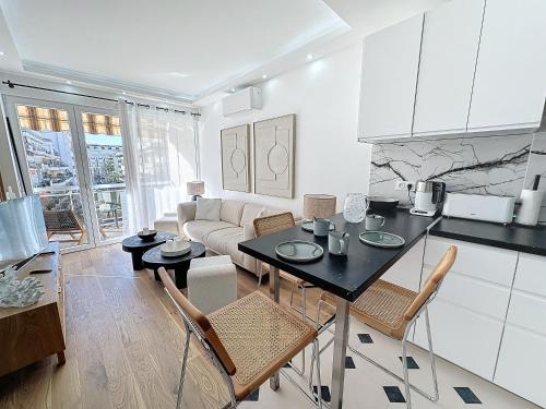 une cuisine et un salon avec une table et des chaises dans l'établissement 50m2 Croisette Martinez, Terrasse vue mer, à Cannes