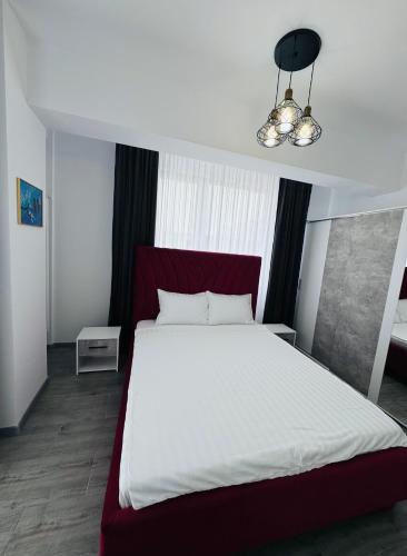 a bedroom with a large white bed with a red headboard at RRed in Năvodari