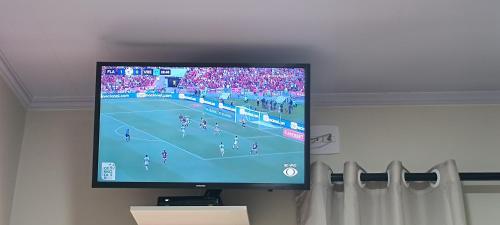 a flat screen tv on a wall with a soccer game at La Bella Luna Suítes in Alto Paraíso de Goiás