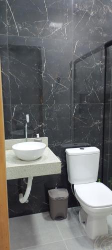 a bathroom with a white toilet and a sink at La Bella Luna Suítes in Alto Paraíso de Goiás