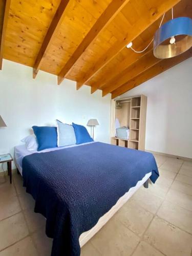 - une chambre avec un lit bleu et un plafond en bois dans l'établissement Jolie petite maison rénovée piscine, à Saint-Palais-sur-Mer