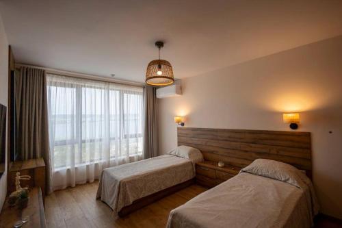 a bedroom with two beds and a large window at Marina Varna Apartment-2BDR at South Bay Complex in Varna City