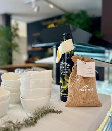 a bottle of wine sitting on a table next to dishes at VENEZIANA Boutique Hotel Superior in Koper