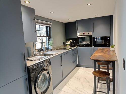 a kitchen with a washer and dryer at Stansted Airport Cottage in Bishops Stortford