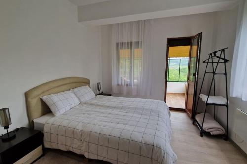 a bedroom with a white bed and a window at ViPo Vista Veliko Tarnovo in Veliko Tŭrnovo