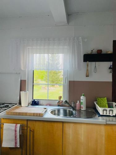 a kitchen counter with a sink and a window at Chatka Oli in Zubacze