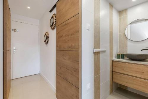 La salle de bains est pourvue d'une porte en bois et d'un lavabo. dans l'établissement Escapade sur l'Île des Pêcheurs, au Cap d'Agde