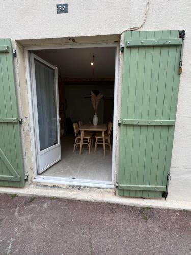 Une porte ouverte s'ouvre sur une terrasse avec une table. dans l'établissement Cœur, à Palavas-les-Flots