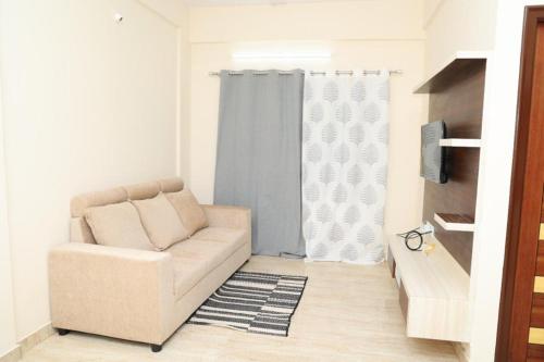 ein Wohnzimmer mit einem Sofa und einem Fenster in der Unterkunft HSR Parkside by Newstays in Bangalore